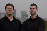 Two Men Smiling with Skyscraper in the Background