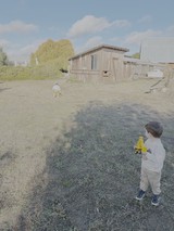 Child Playing with Toy Truck in Rural Farmyard