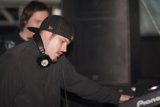 Black Shirted Travis B Wears Baseball Cap and Headphones