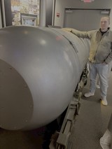 Man Posing with Large Cylindrical Military Equipment