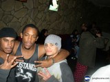 Three Young Men Strike a Pose at a Club Party
