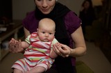 Mother Holding Alert Baby in Colorful Striped Outfit