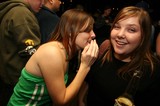 Two Friends Share a Secret at Nighttime Party