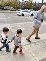 Father and Sons Walking Through Urban Sidewalk