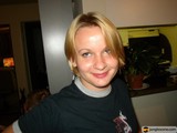 Blonde Woman Smiling Next To Potted Plant