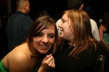 Two Friends Share a Whispered Secret at Nightclub