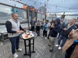 Cake Celebration Caption: Anand J enjoys a slice of cake at a restaurant overlooking the cityscape of San Francisco.