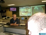 Man in Blue Shirt Multi-Tasking on Three Screens
