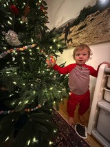 Toddler Decorating Christmas Tree in Festive Pajamas