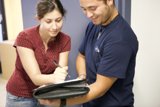 A couple reviewing paperwork Caption: A man and a woman examining a document featuring their jewelry and clothing accessories.