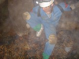 Spelunker Navigates Misty Underground Cave Passage