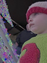 Child Mesmerized by Colorful Light Display
