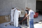 Four men working on a wooden form for a concrete wall