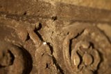 Intricate Carvings on Rusty Stone Wall