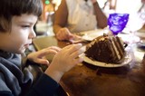 Young Boy Anticipating a Decadent Chocolate Cake
