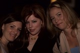 Three Women Smiling Together at a Nighttime Venue