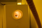 Illuminated Hole in White Wall