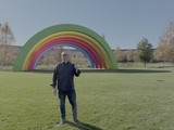 Man Poses with Giant Rainbow Art Installation