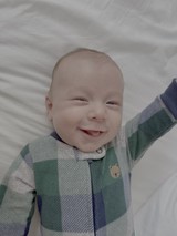 Smiling Baby in Colorful Striped Sleeper