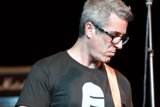 Brett Gurewitz strums his guitar with ease