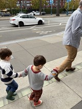 Father and Two Sons Walking on Urban Sidewalk