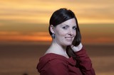 Dark-Haired Woman Smiling at Sunset by Sea