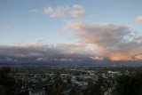 View of cityscape and cumulus clouds from a hill