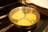 Three eggs sizzling on the stove