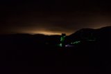 A Green Laser Illuminating a Mountain at Night