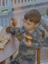 Toddler Enjoying Donuts at Breakfast Table