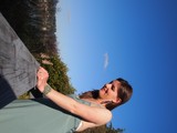Woman in Teal Dress Gazes Skyward at Outdoor Venue