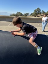 Young Boy Mid-Jump on Trampoline in California Backyard