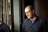 Two men with smiles, glasses and black shirts