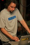 Grey Shirted Man Working on Two Laptops