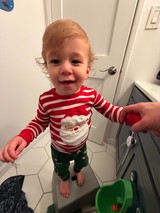 Toddler in Festive Christmas Pajamas in Bathroom