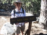 Hiker Poses at Warming Hut Trail Sign