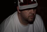 Hat-wearing man in a dark room