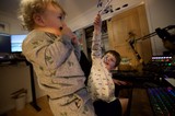 Two Children Playing at Gaming Setup in Pajamas