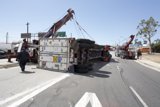 Crane lifting overturned truck on street