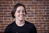 Smiling Woman Against Brick Wall