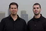 Two Men Smiling in Front of a Skyscraper