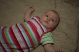 Curious Newborn Baby Lying on Knit Blanket