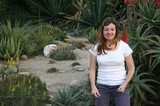 Woman Smiling Among Desert Succulents and Aloe