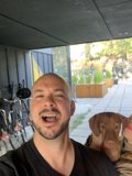 Man and Dog Strike a Pose with Potted Plant