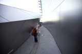 Woman Explores Curved Steel Walls of Walt Disney Concert Hall