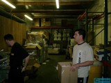 Two Men in a Warehouse Surrounded by Cardboard Boxes