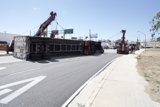 Crane lifting overturned truck on the street