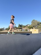Young Boy Walking on Rooftop Edge at Skate Park