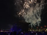 Fireworks Illuminate the Night Sky over a Concert Crowd