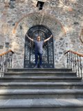 Man in Jeans Standing on Steps of Stone Building